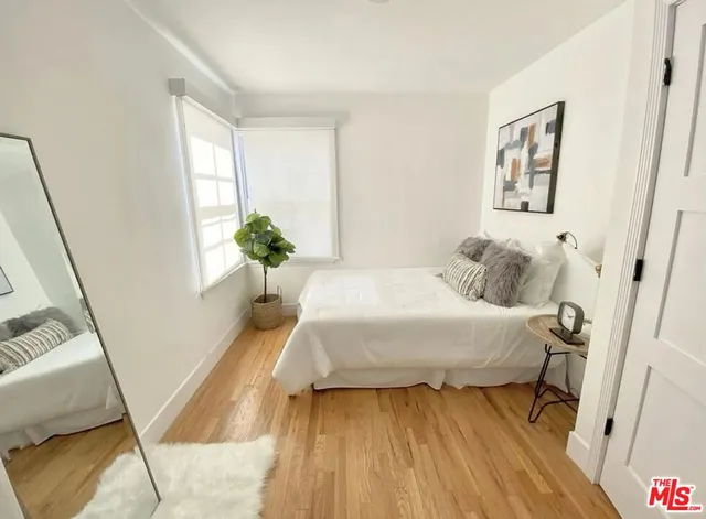 a bedroom with a bed and wooden floor