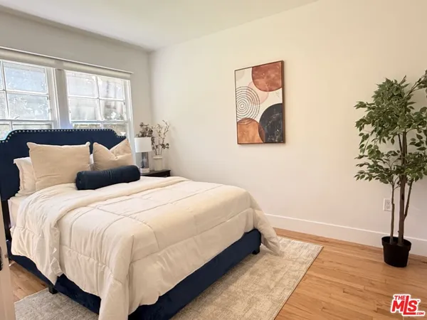 a bedroom with a bed and a potted plant