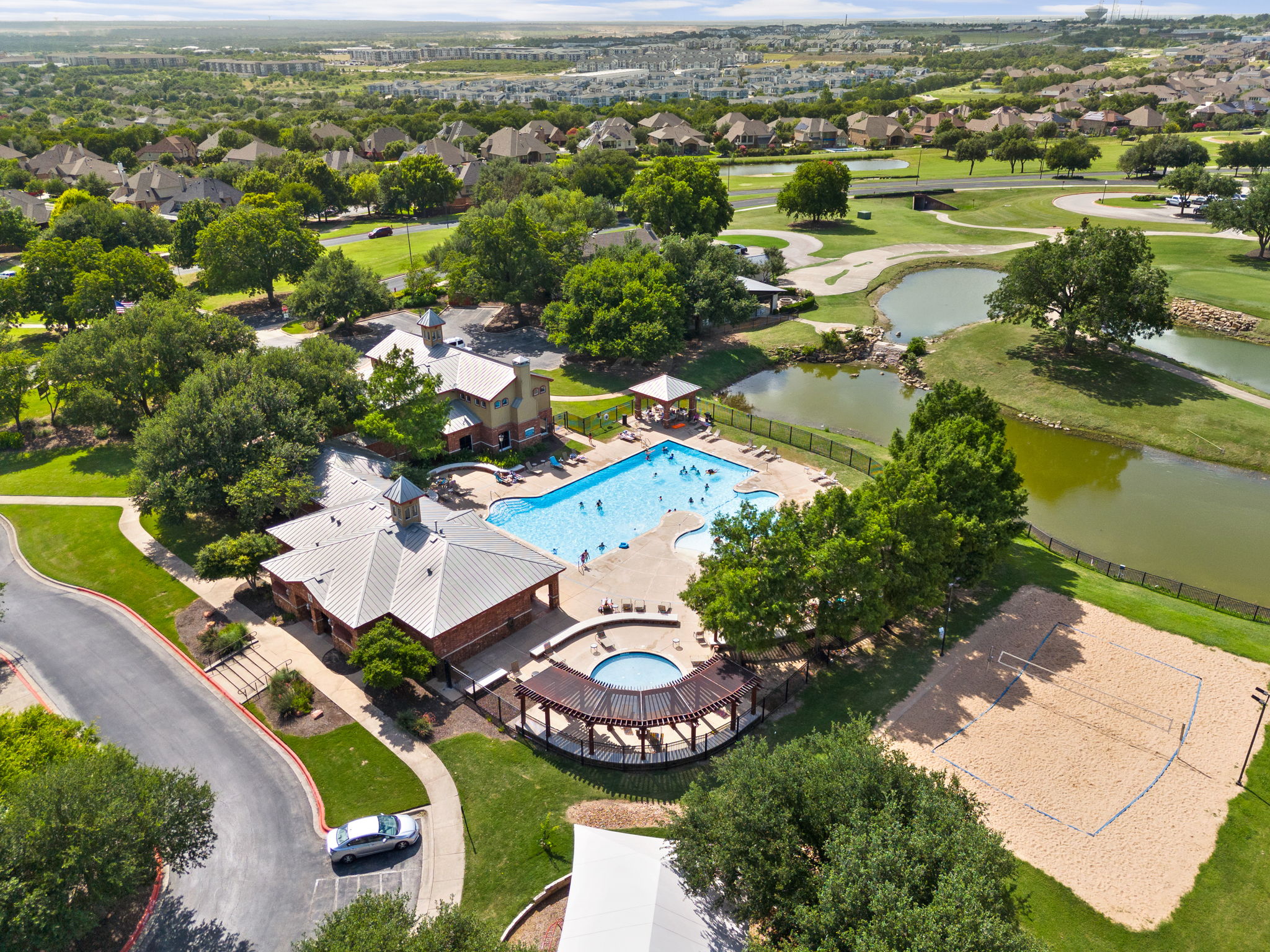440 Cherokee Rose Circle Georgetown, TX 78626 - Photo 35 of 39 An aerial perspective reveals a vibrant community hub with a sparkling pool, recreation areas, and lush landscaping.