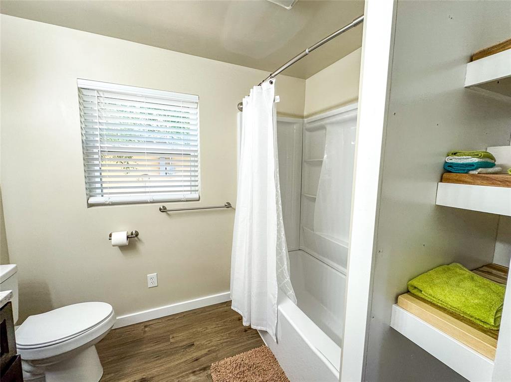 505 Main Street Rochester, TX 79544 - Photo 14 of 24 a bathroom with a granite countertop shower a toilet and a sink
