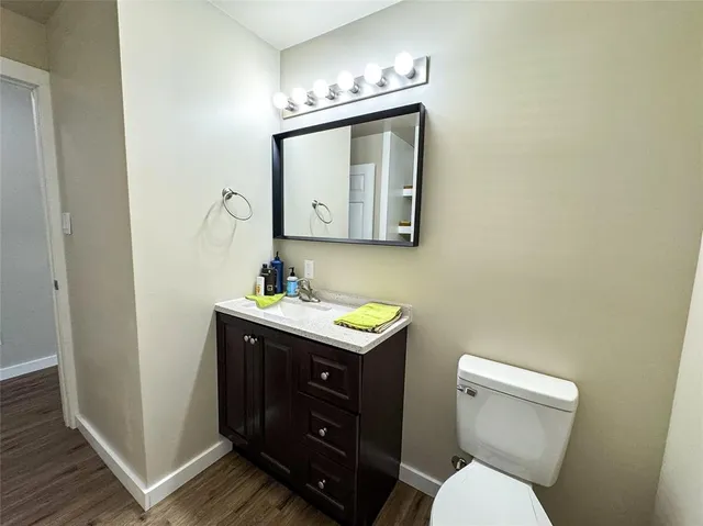 a bathroom with a toilet sink vanity and mirror
