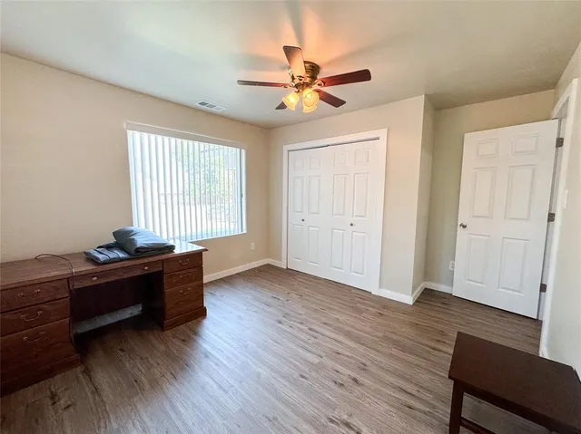 a view of a livingroom with wooden floor and a ceiling fan