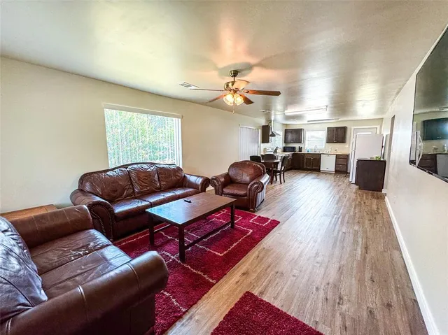 a living room with furniture a ceiling fan and a rug
