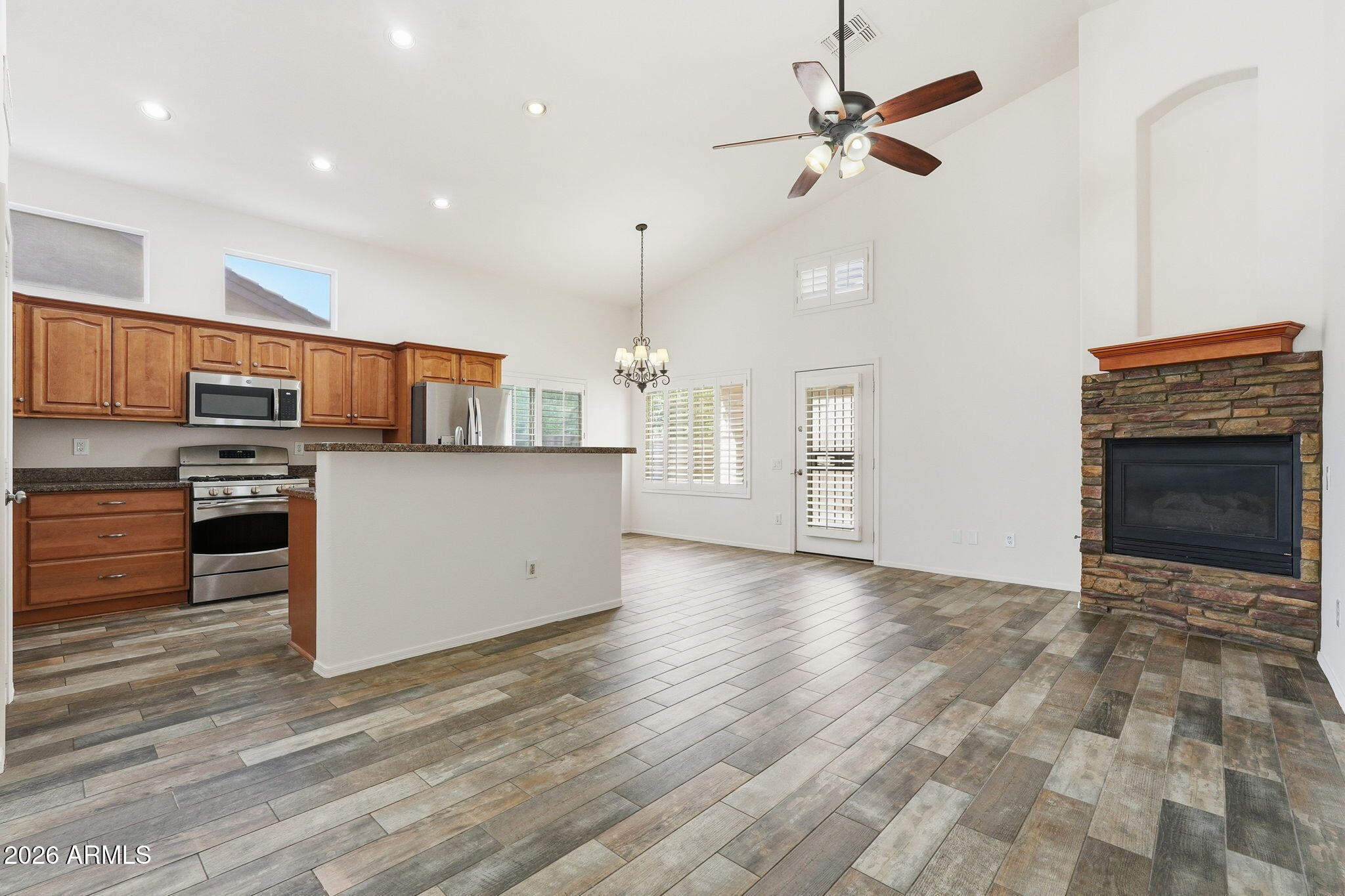 742 North Boulder Street Gilbert, AZ 85234 - Photo 11 of 22 a kitchen with stainless steel appliances a stove a refrigerator white cabinets and a chandelier