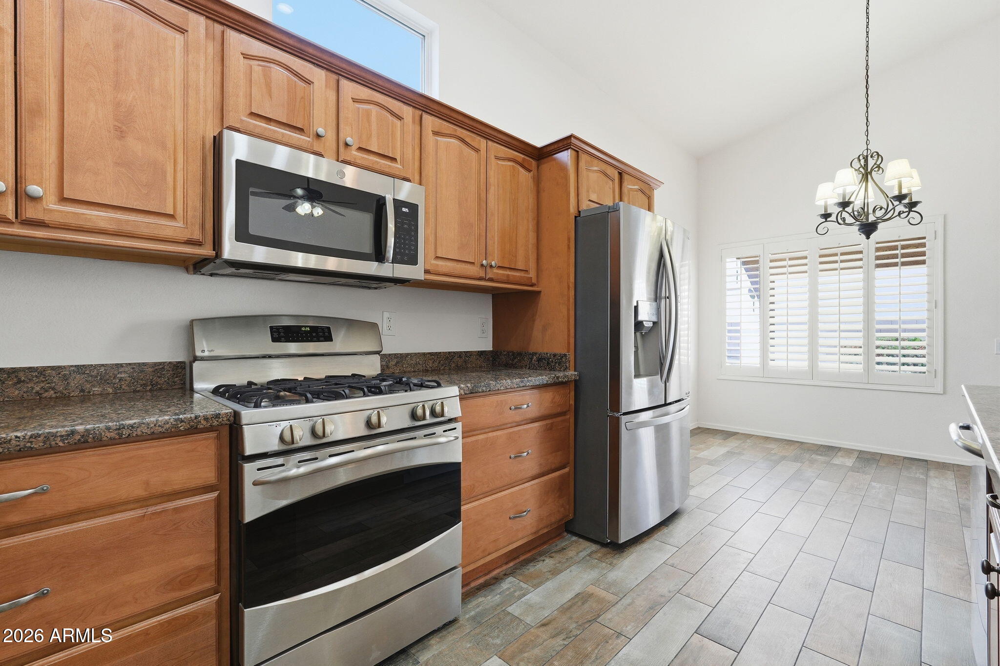 742 North Boulder Street Gilbert, AZ 85234 - Photo 9 of 22 a kitchen with stainless steel appliances granite countertop a stove a microwave and a refrigerator