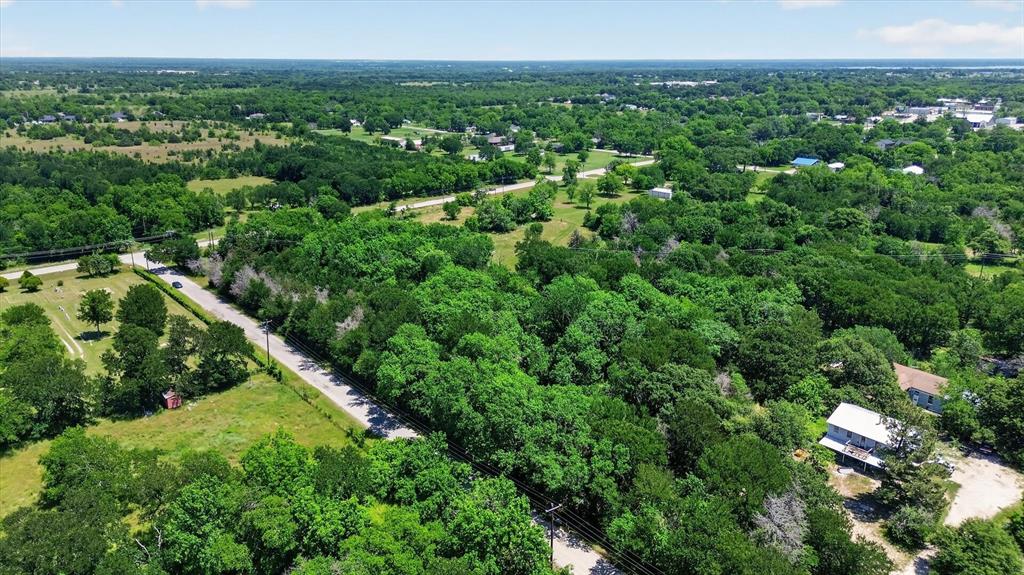 613 Main Street Quinlan, TX 75474 - Photo 4 of 16 Expansive verdant landscape featuring a dense tree canopy, open grassy areas, and a visible roadway
