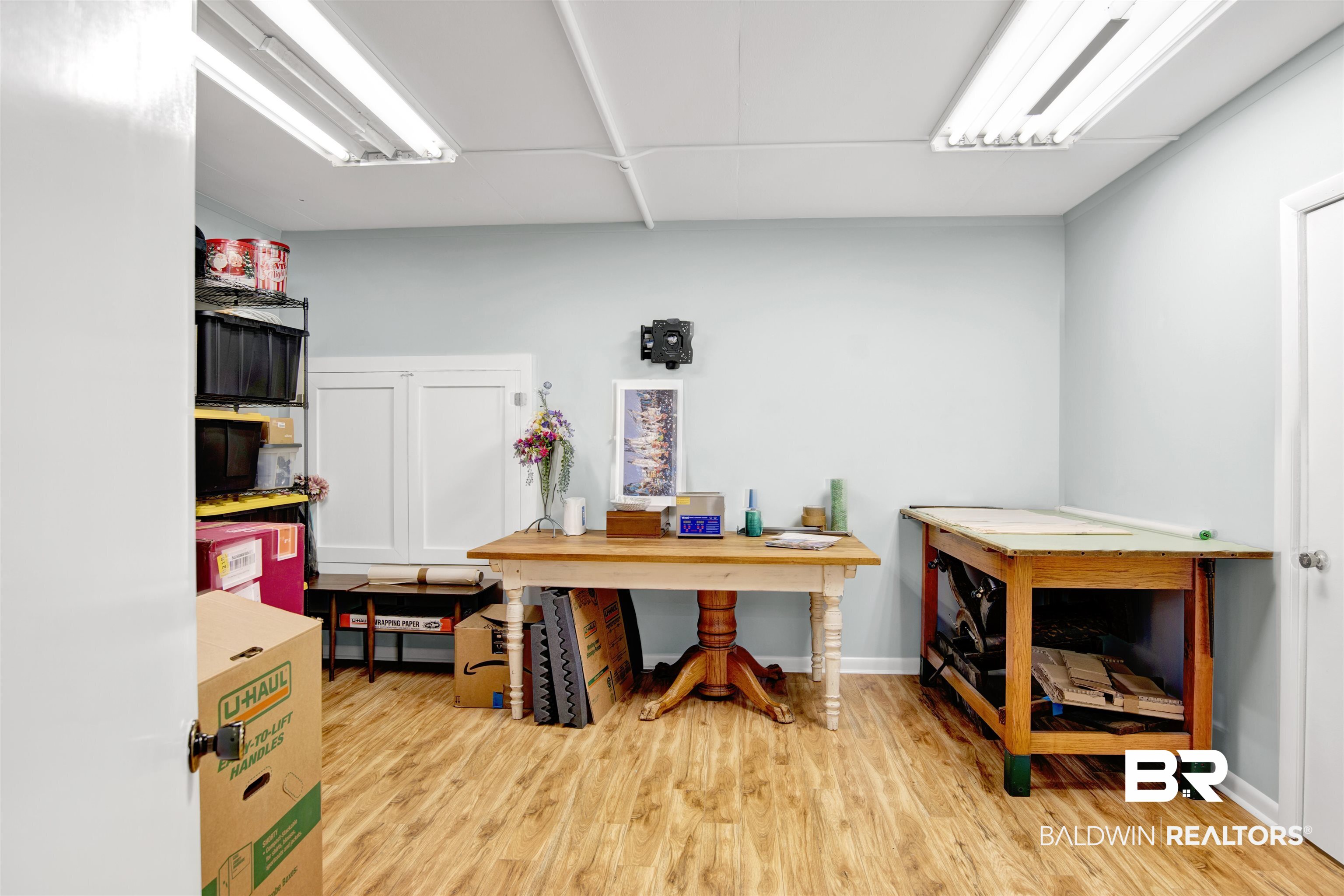 809 Bernard Circle Mobile, AL 36693 - Photo 42 of 75 Spacious room featuring wood-finish flooring, light blue walls, and a white drop ceiling with fluorescent lighting
