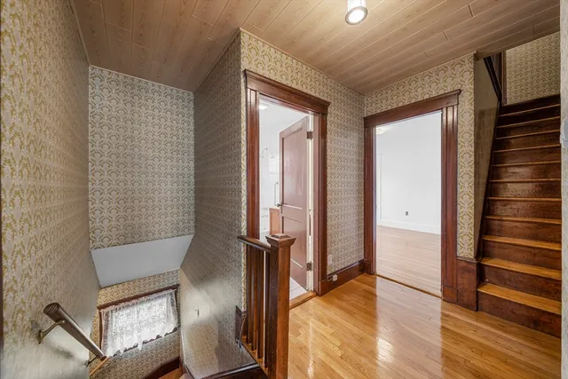 a view of hallway with stairs and wooden floor