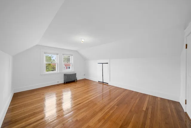 a view of empty room with wooden floor and window