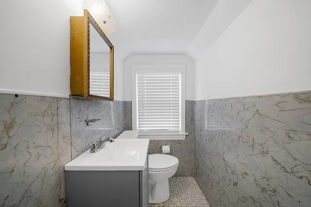 a bathroom with a sink a toilet and mirror