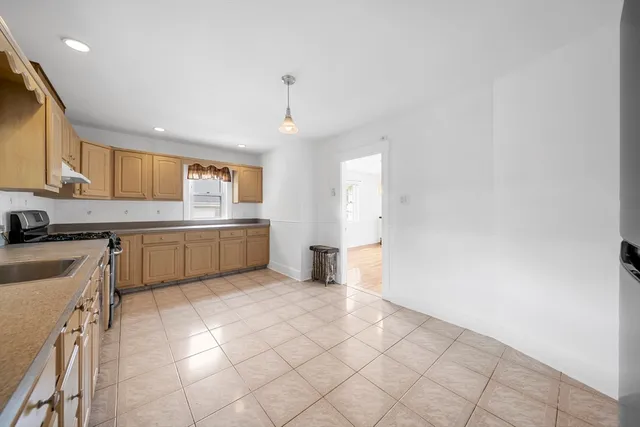 a kitchen with a sink a stove cabinets and a window