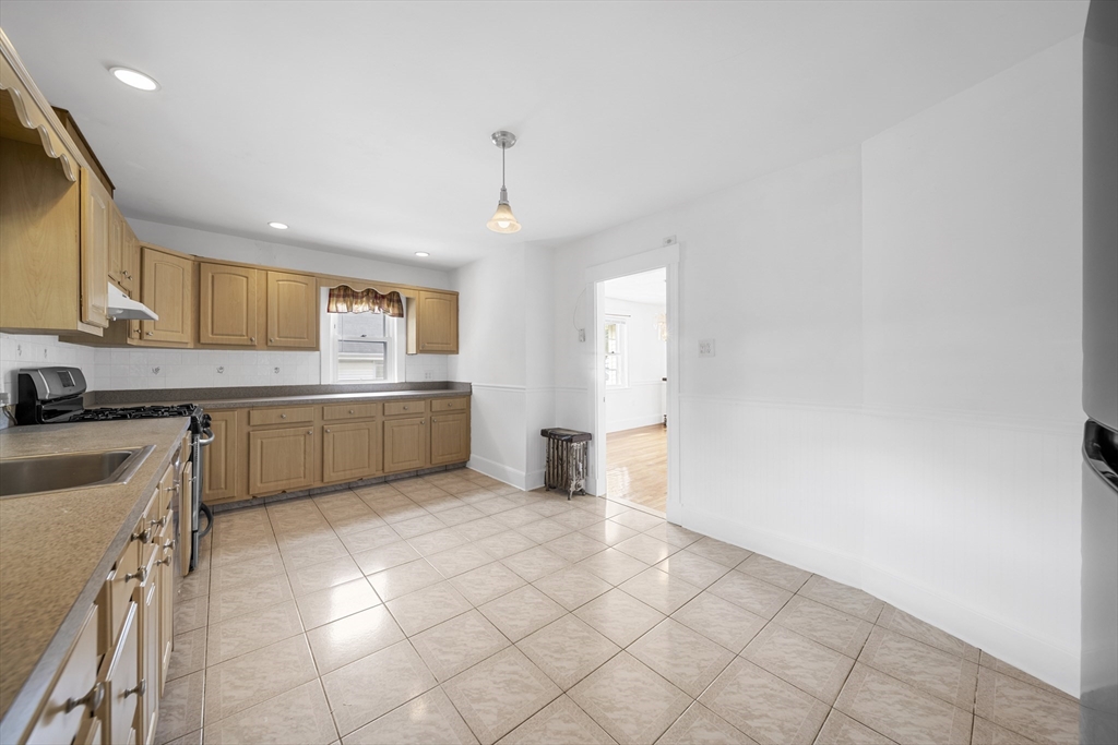 180 Faneuil Street, Unit 2 Boston, MA 02135 - Photo 4 of 37 a kitchen with a sink a stove cabinets and a window