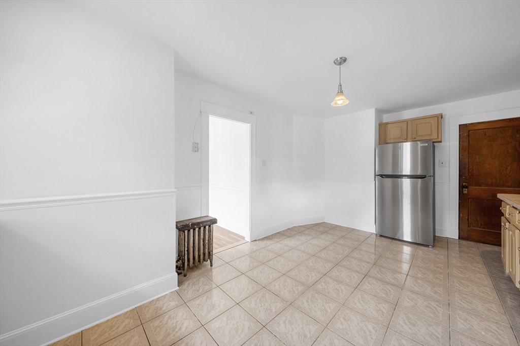 180 Faneuil Street, Unit 2 Boston, MA 02135 - Photo 5 of 37 a view of empty room with wooden floor and kitchen