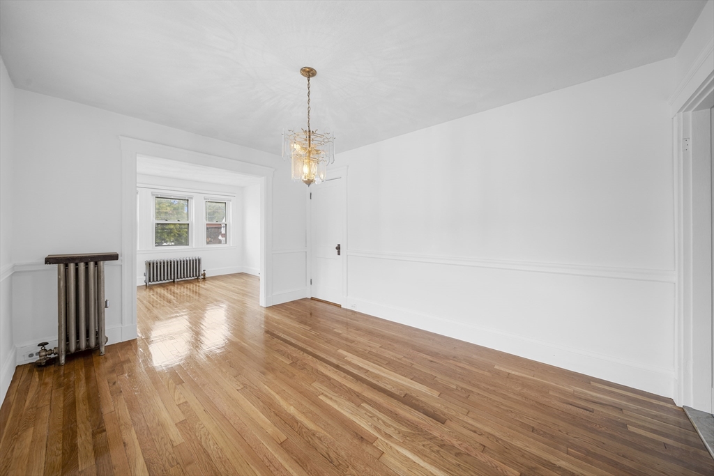 180 Faneuil Street, Unit 2 Boston, MA 02135 - Photo 8 of 37 a view of empty room with wooden floor and fan