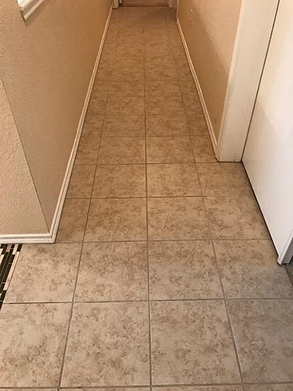 3142 Aspen Fair Trail Spring, TX 77389 - Photo 10 of 22 This image shows a narrow hallway with light beige tile flooring and neutral-colored walls, creating a clean and simple look.
