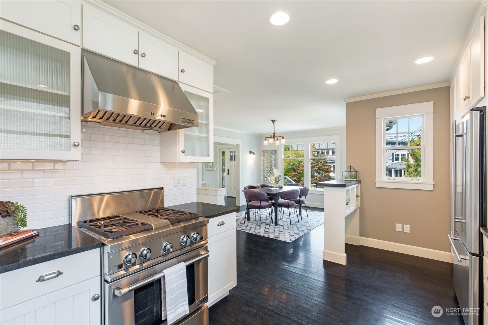 3130 Broadway East Seattle, WA 98102 - Photo 16 of 32 a kitchen with stainless steel appliances a stove and white cabinets with wooden floor