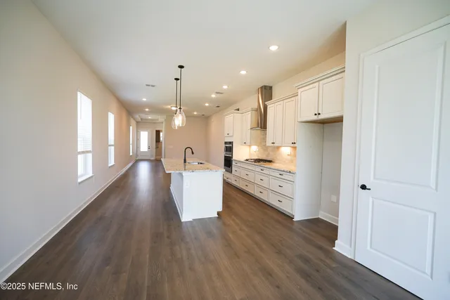 a kitchen with a dining table chairs and wooden floor