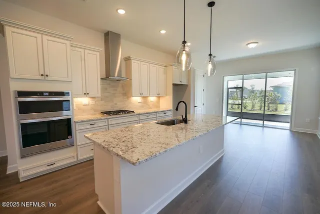 a view of a kitchen area with furniture and wooden floor