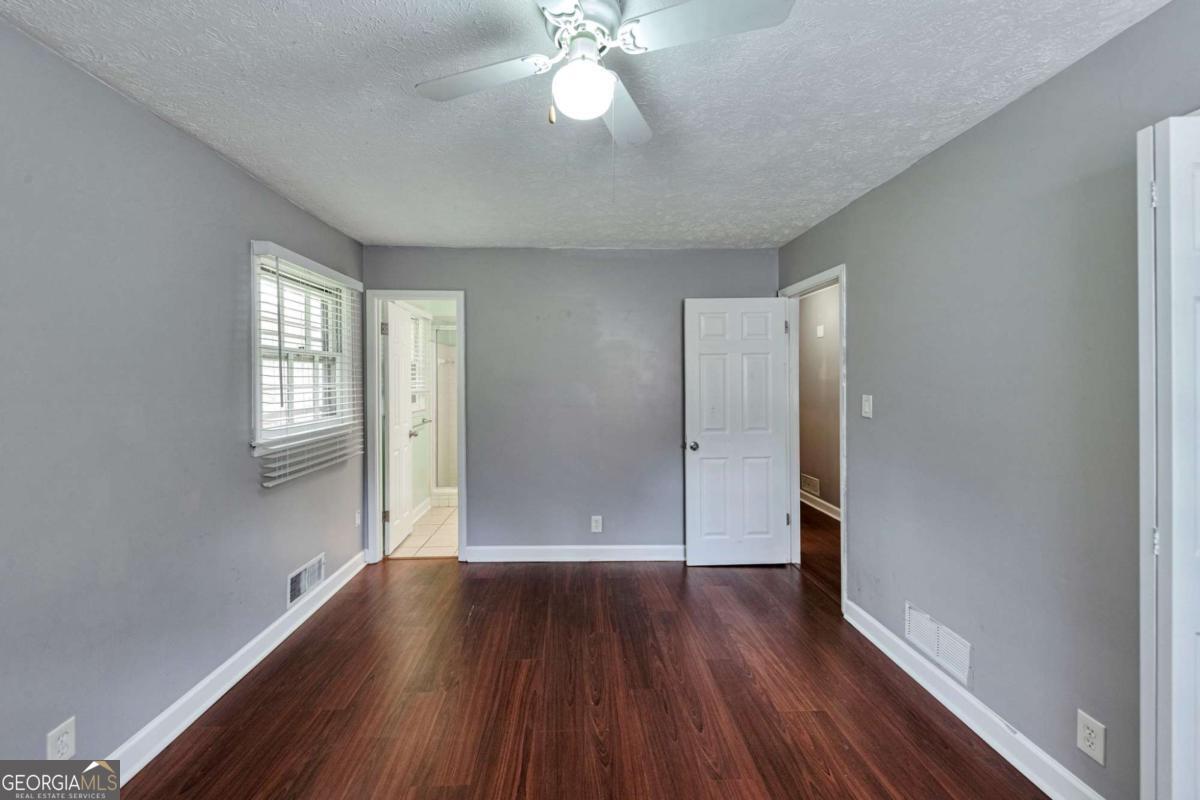 115 Elizabeth Way Ellenwood, GA 30294 - Photo 11 of 15 an empty room with wooden floor and windows