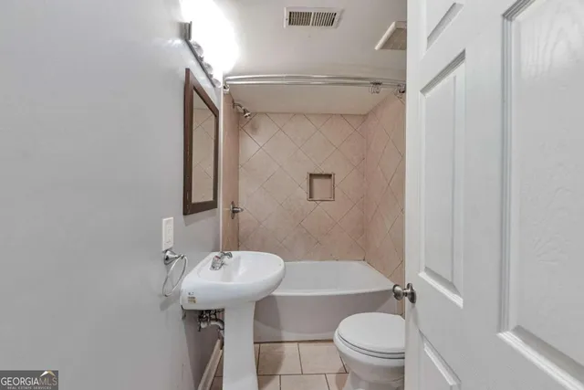a bathroom with a sink toilet and a mirror