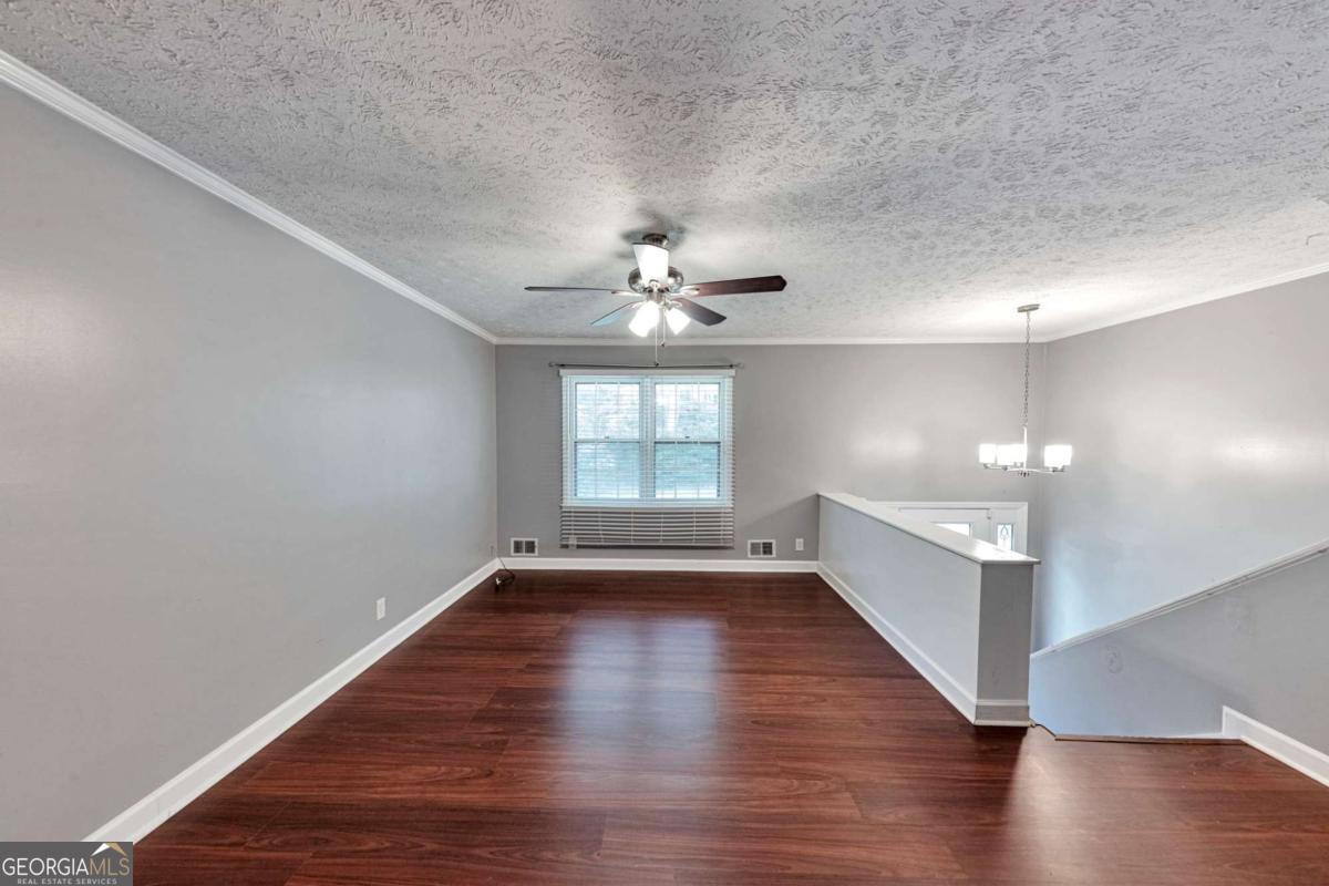 115 Elizabeth Way Ellenwood, GA 30294 - Photo 2 of 15 a view of an empty room with wooden floor and a window