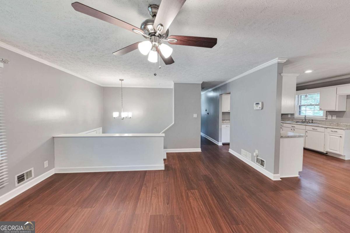 115 Elizabeth Way Ellenwood, GA 30294 - Photo 3 of 15 a view of an empty room with wooden floor and a ceiling fan