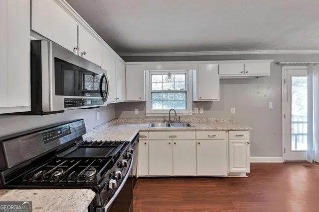 a kitchen with stainless steel appliances a sink stove and cabinets