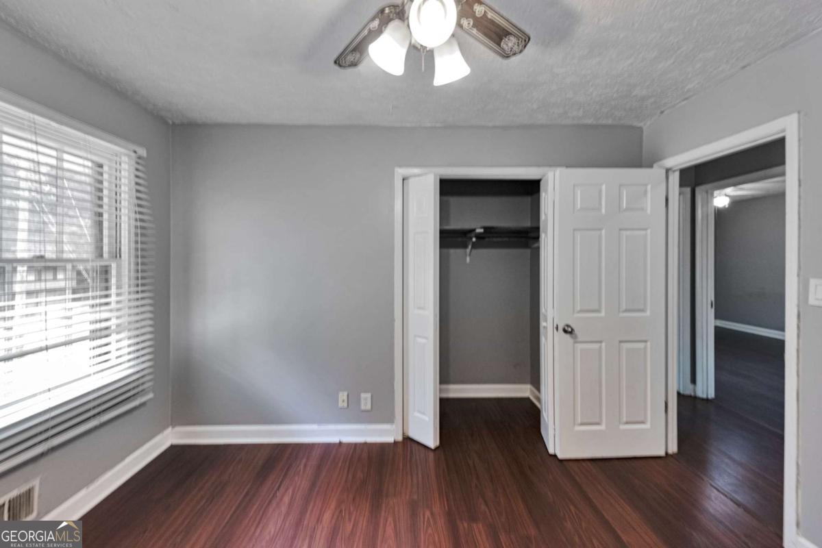 115 Elizabeth Way Ellenwood, GA 30294 - Photo 8 of 15 an empty room with wooden floor and windows