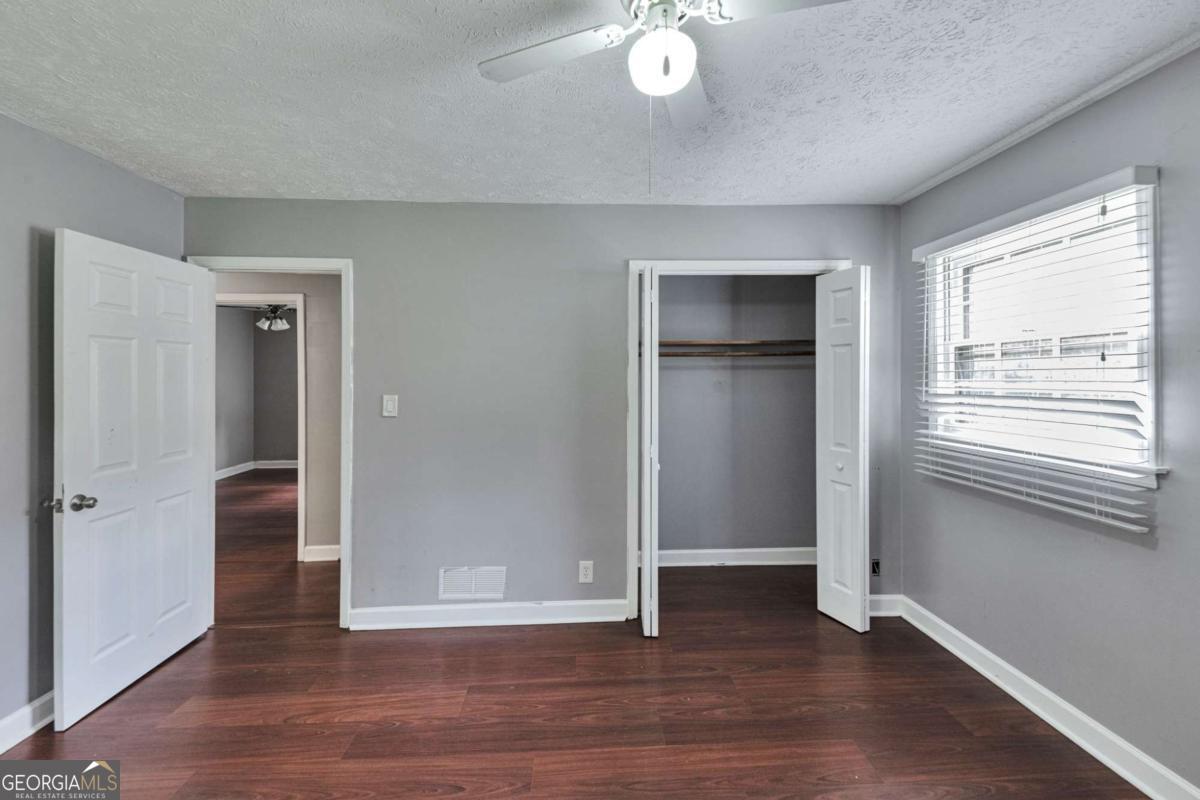 115 Elizabeth Way Ellenwood, GA 30294 - Photo 10 of 15 an empty room with wooden floor closet and windows