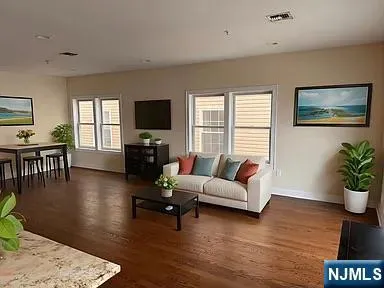 a living room with furniture and a flat screen tv with wooden floor