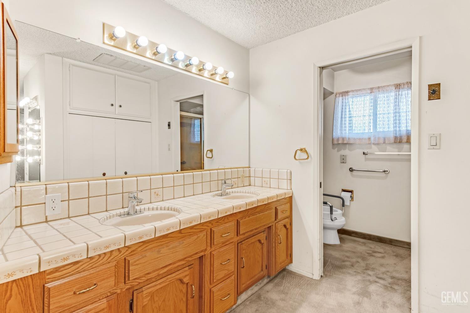 Undisclosed Address Bakersfield, CA 93309 - Photo 11 of 46 a spacious bathroom with a double vanity sink mirror and