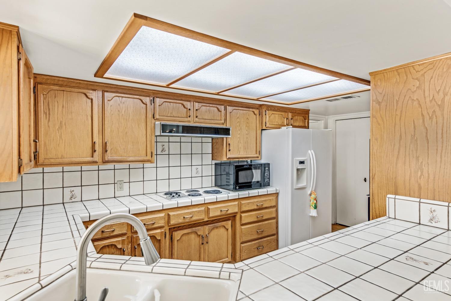 Undisclosed Address Bakersfield, CA 93309 - Photo 20 of 46 a kitchen with stainless steel appliances kitchen island granite countertop a refrigerator and a sink