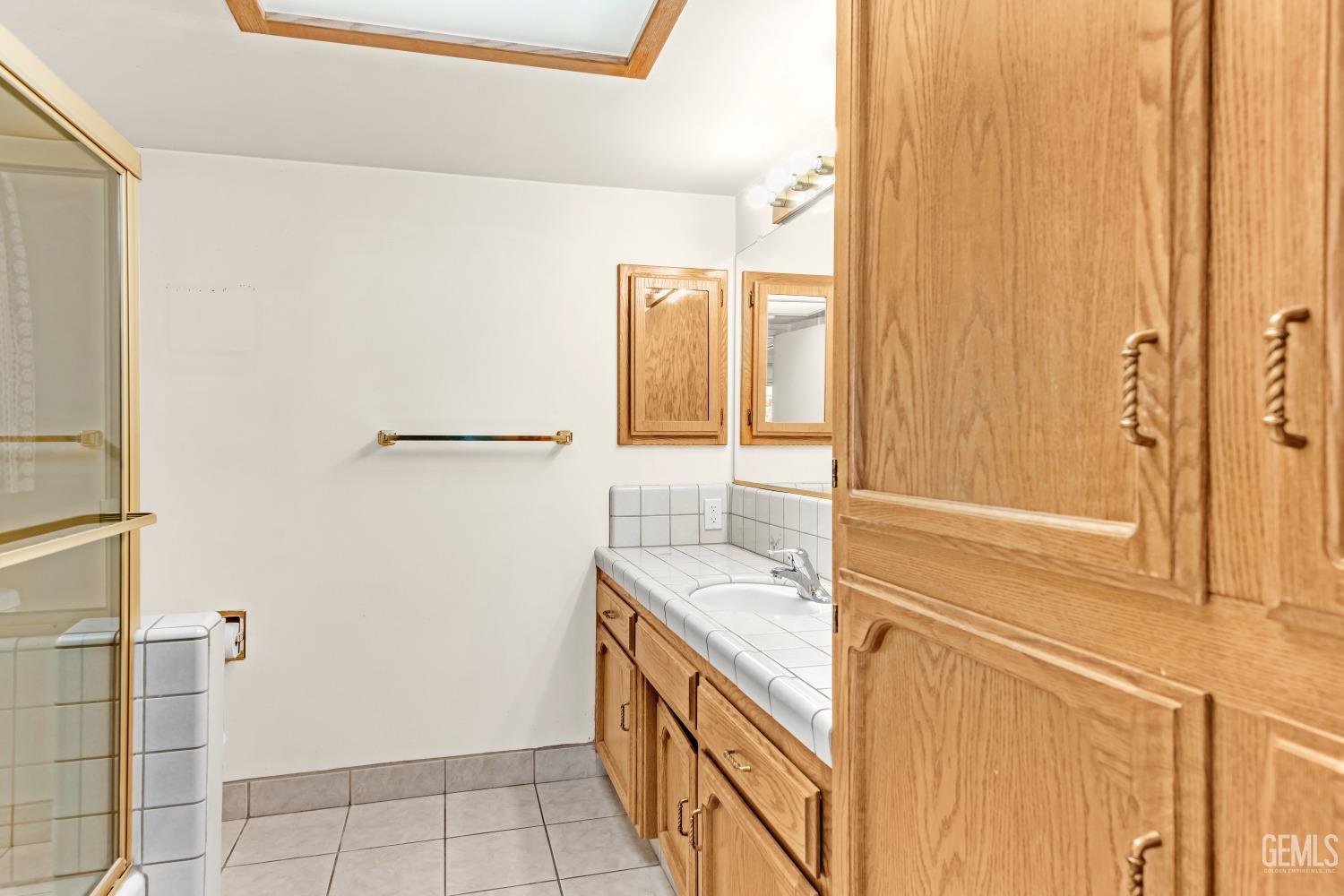 Undisclosed Address Bakersfield, CA 93309 - Photo 28 of 46 a bathroom with a granite countertop sink and a mirror