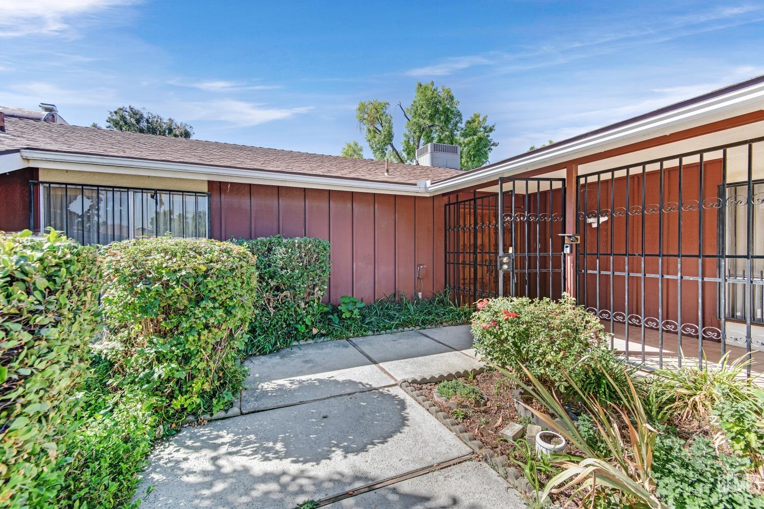 Undisclosed Address Bakersfield, CA 93309 - Photo 4 of 46 a front view of a house with a garden