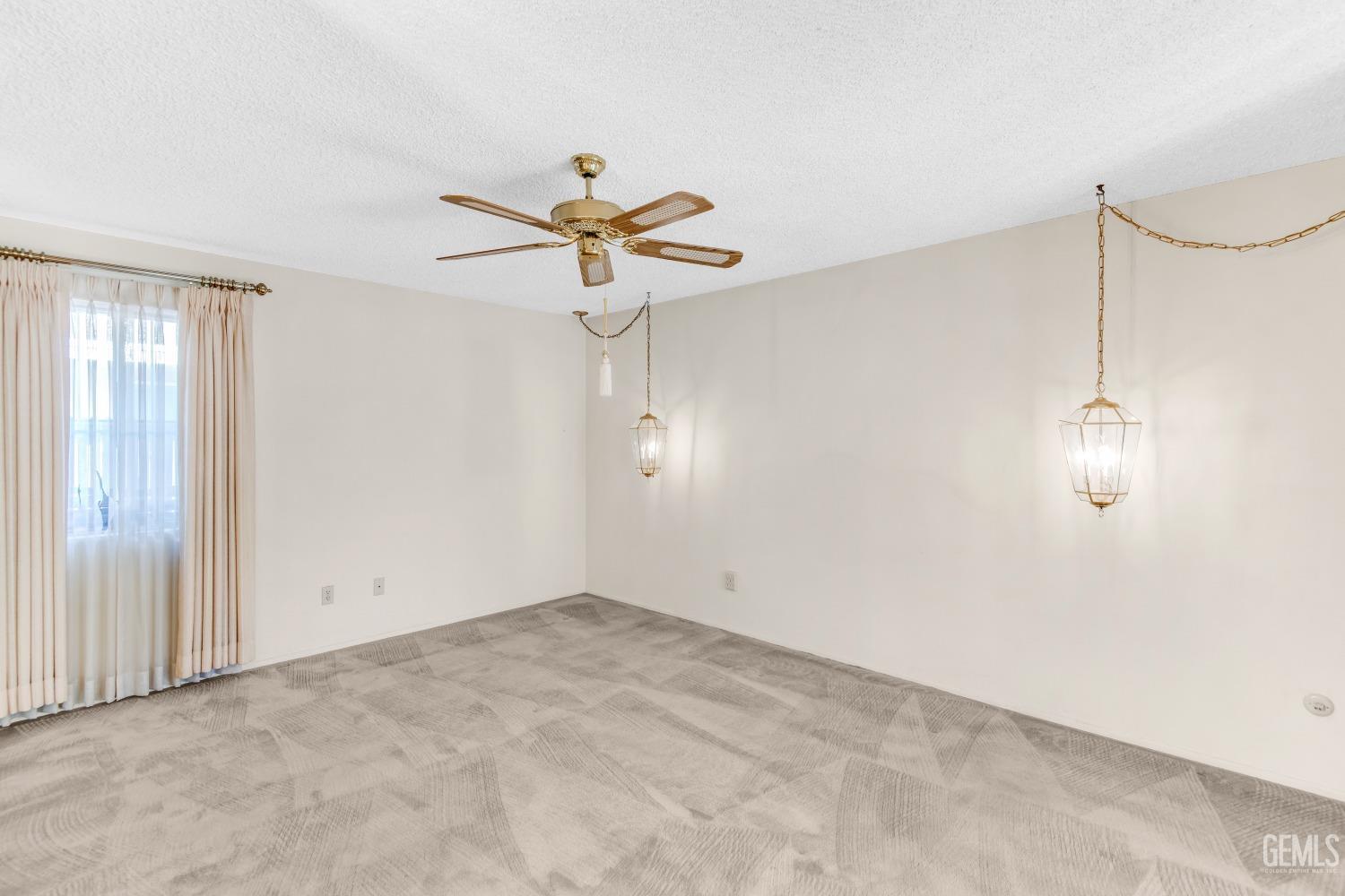 Undisclosed Address Bakersfield, CA 93309 - Photo 7 of 46 an empty room with a chandelier fan and windows