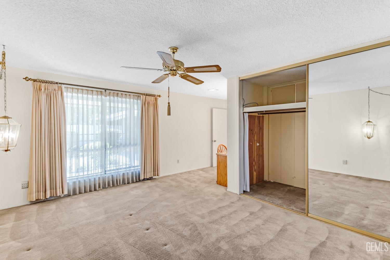 Undisclosed Address Bakersfield, CA 93309 - Photo 8 of 46 an empty room with ceiling fan and windows