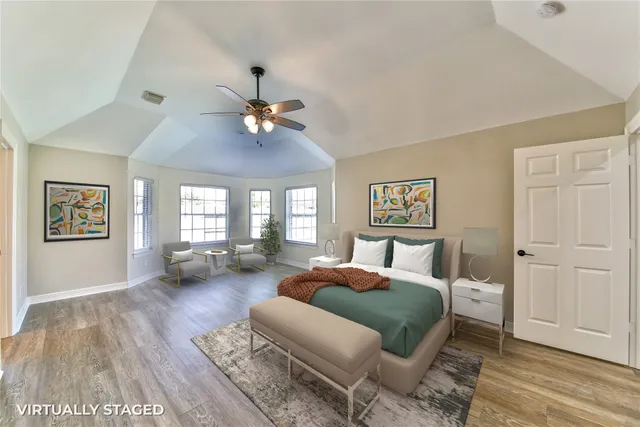 a spacious bedroom with a bed couch and a window