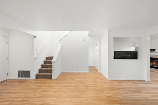 a view of a livingroom with wooden floor and stairs