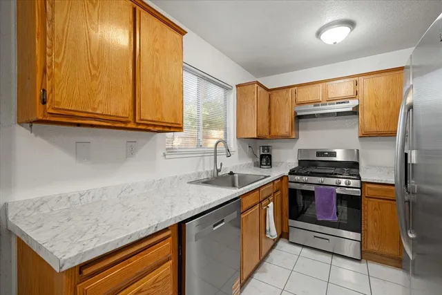a kitchen with stainless steel appliances granite countertop a sink stove and refrigerator