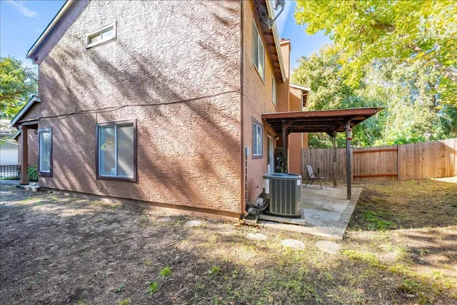 a view of a backyard with wooden fence and large trees