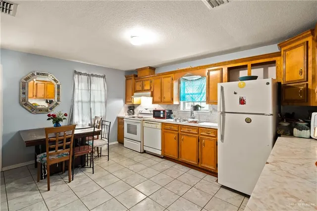 a kitchen with granite countertop cabinets a dining table and a sink