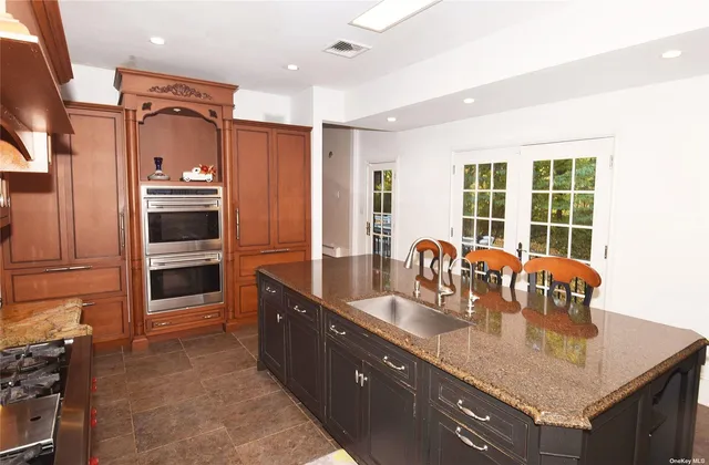 a kitchen with granite countertop a refrigerator a stove and a sink
