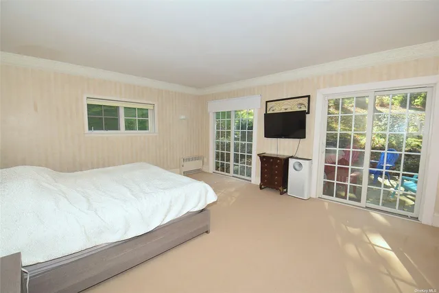 a spacious bedroom with a bed and a flat screen tv