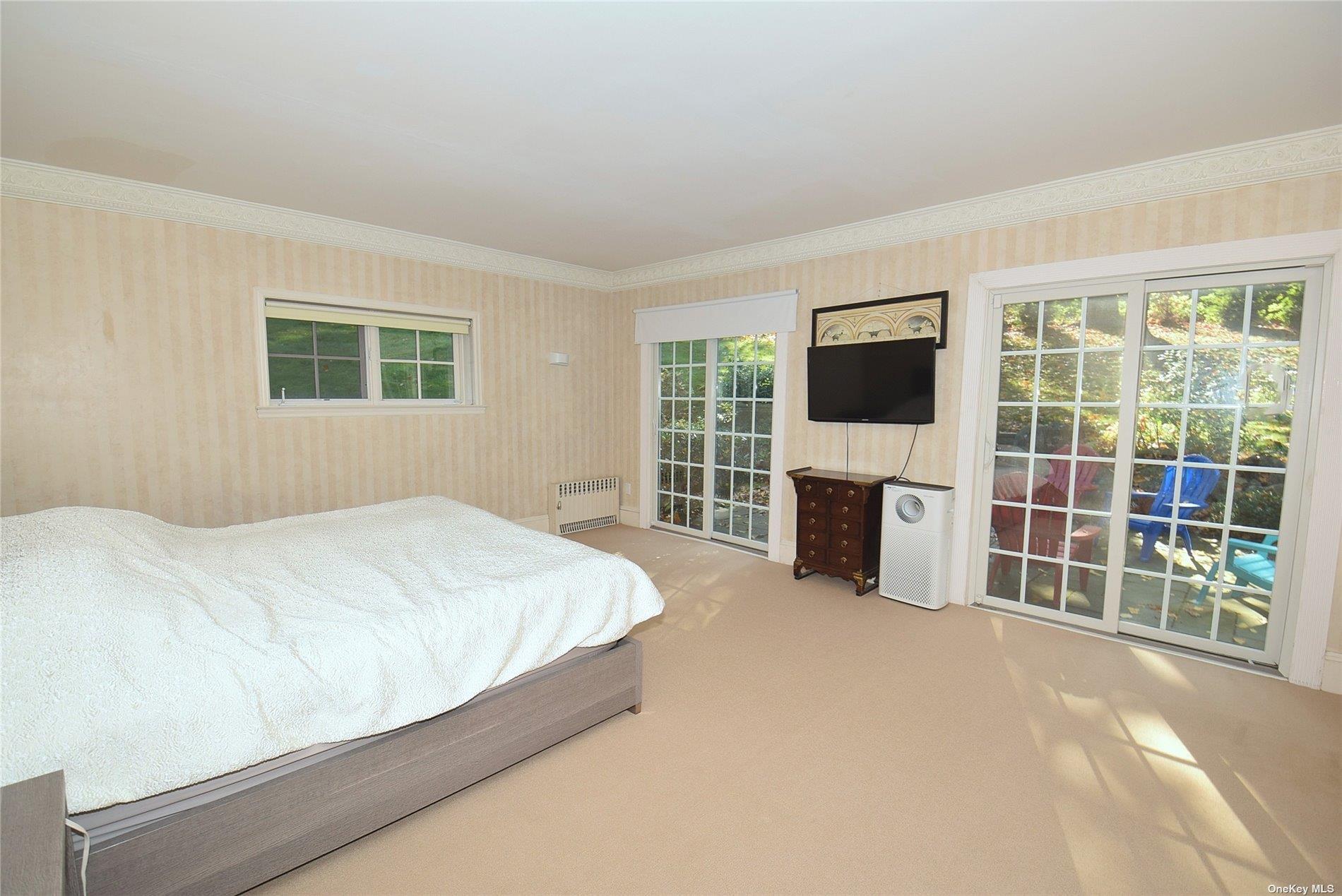 539 Manhasset Woods Road Manhasset, NY 11030 - Photo 16 of 30 a spacious bedroom with a bed and a flat screen tv