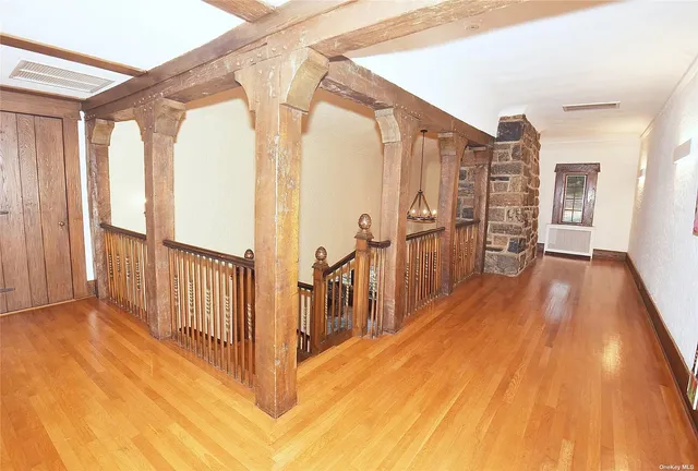 a view of hallway with wooden floor and windows