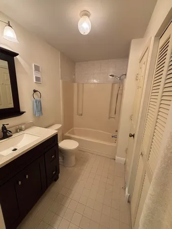 a bathroom with a double vanity sink toilet mirror and bathtub