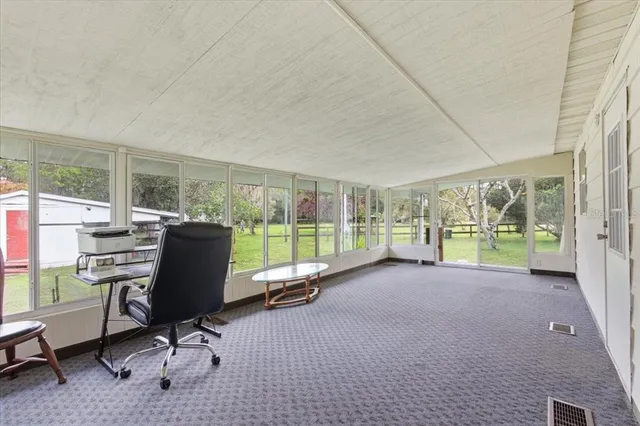 a view of a big room with balcony and floor to ceiling window
