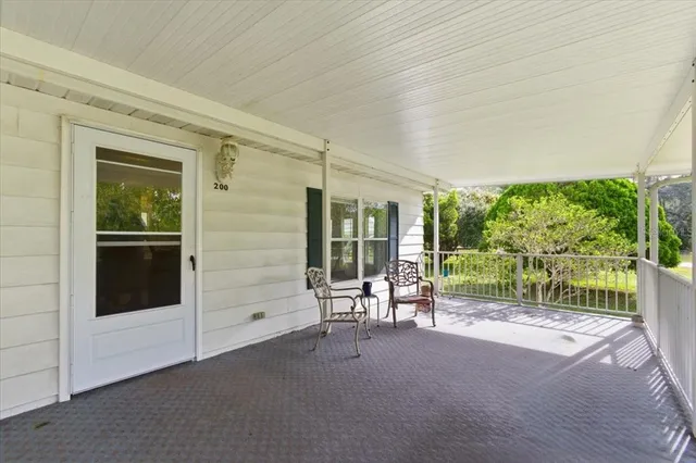 a view of an empty room with wooden floor and a porch