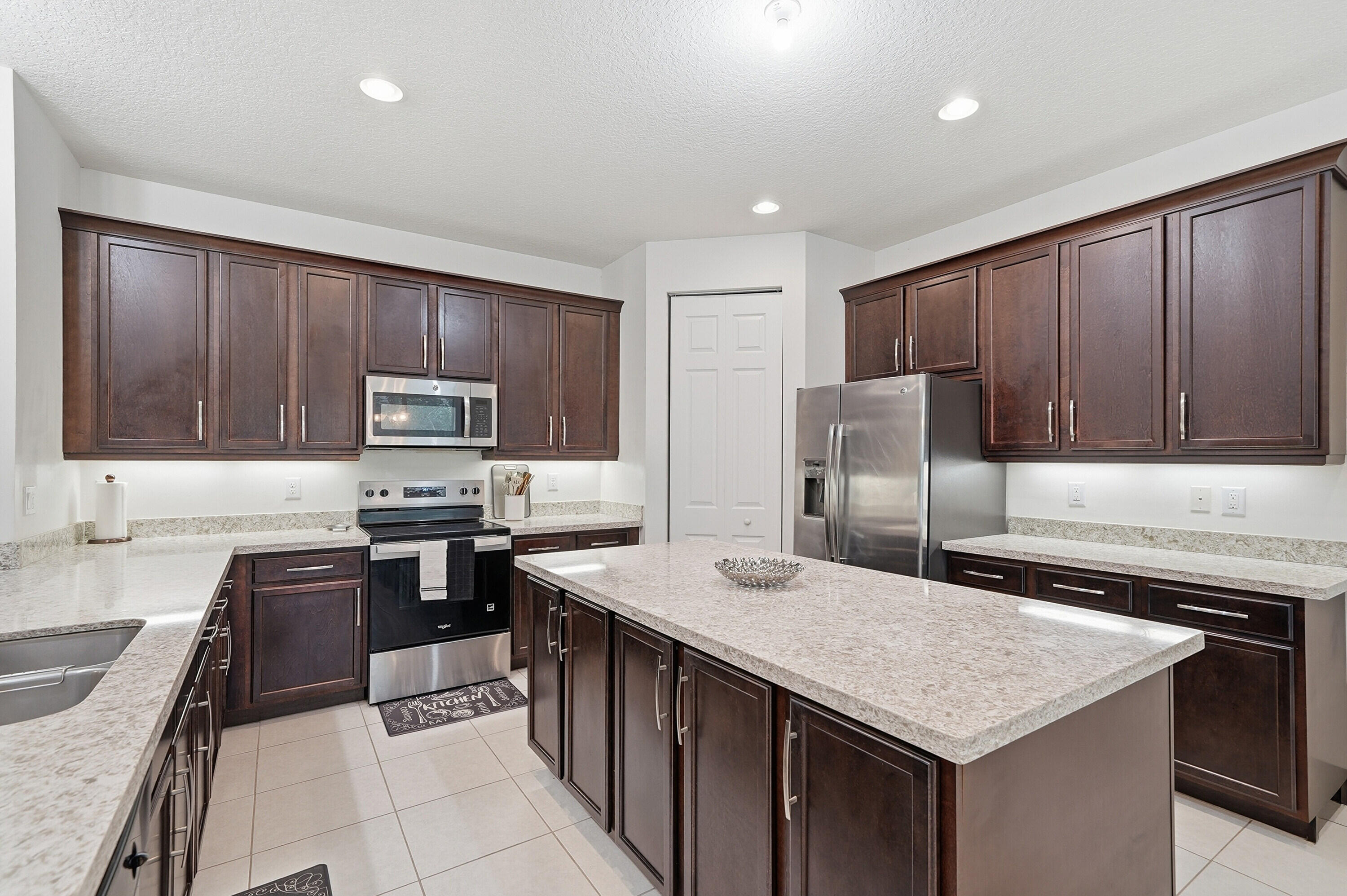 14085 Paverstone Terrace Delray Beach, FL 33446 - Photo 11 of 46 a kitchen with stainless steel appliances a stove sink microwave and cabinets
