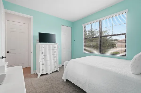 a bedroom with a bed and a flat tv screen on dresser